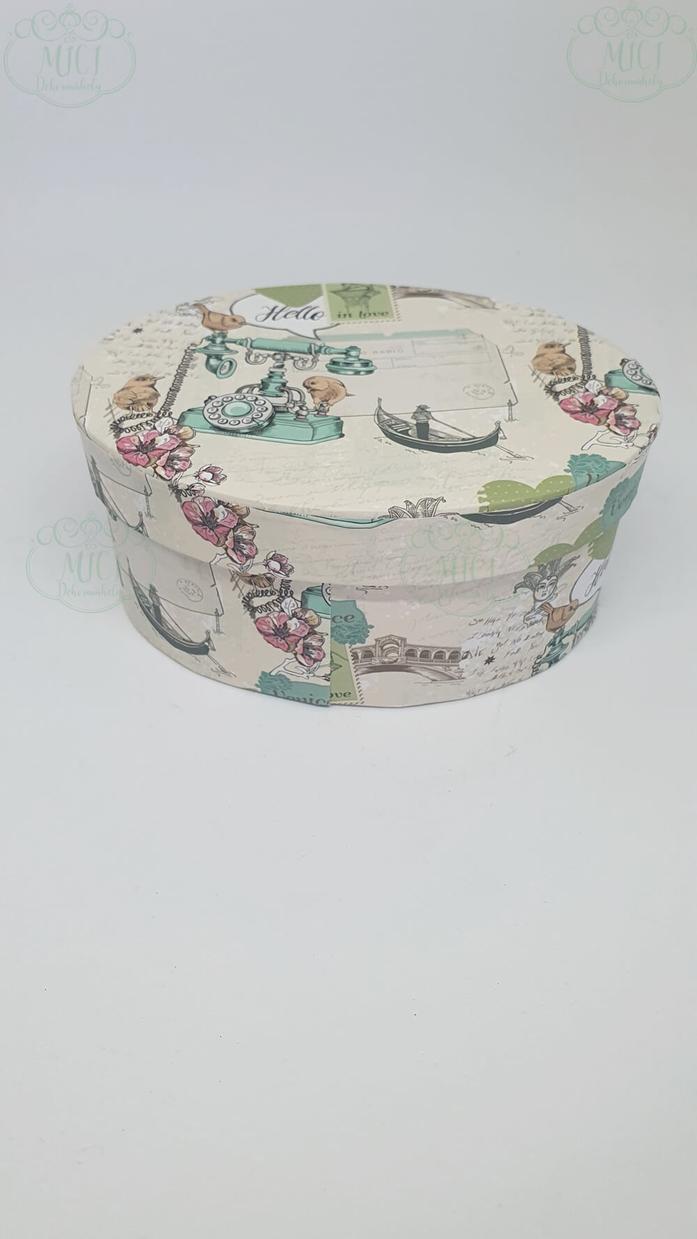 Papírdoboz színes-mintás kivitelben. Ovális formájú. Méretei: hosszúsága:13cm magassága:6cm szélessége:9cm Kiegészítõje lehet: virágbox